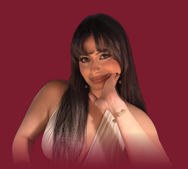 Alia Naguib resting her chin on her hand against a deep red background